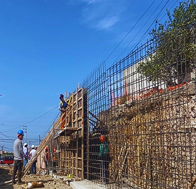 Estructura con acero, encofrado y personal trabajando