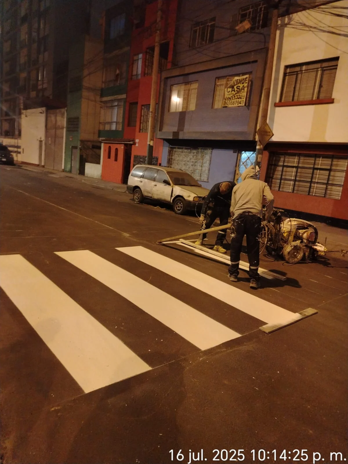 Trabajadores ejecutando señalización vial peatonal de noche